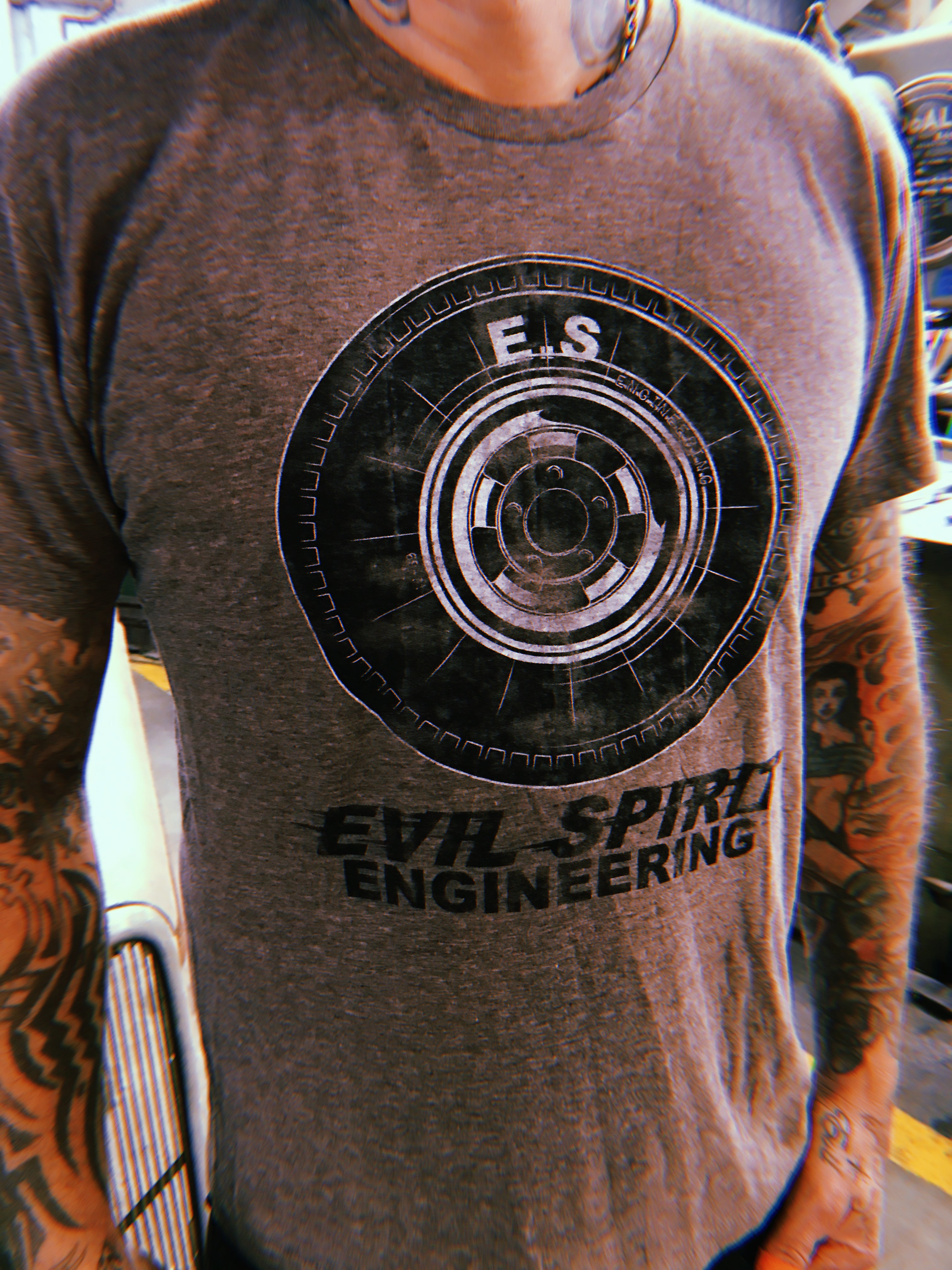 Brown heather shirt with halibrand wheel logo on top, with E.S. letters in white on the tire, and "Evil Spirit Engineering" text below in black.